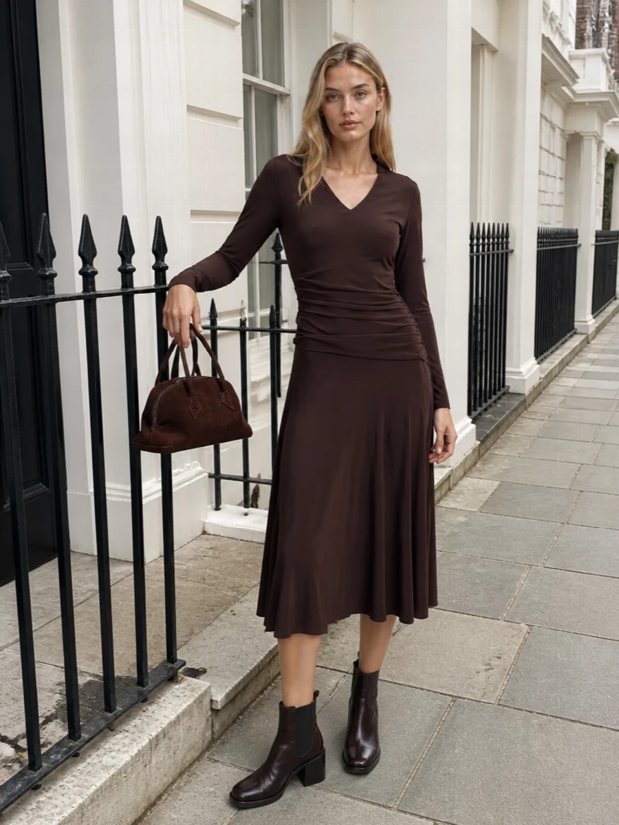 I chose the dress route here so the chocolate Chelsea boots can frame one continuous, quietly sensual column of brown rather than compete with tailoring breaks. The ruched Tory Burch midi brings movement and ease, its deep tone echoing the boots for a harmonious, evening-ready palette. A compact dark suede mini tote keeps everything feeling intentionally pared back and modern.