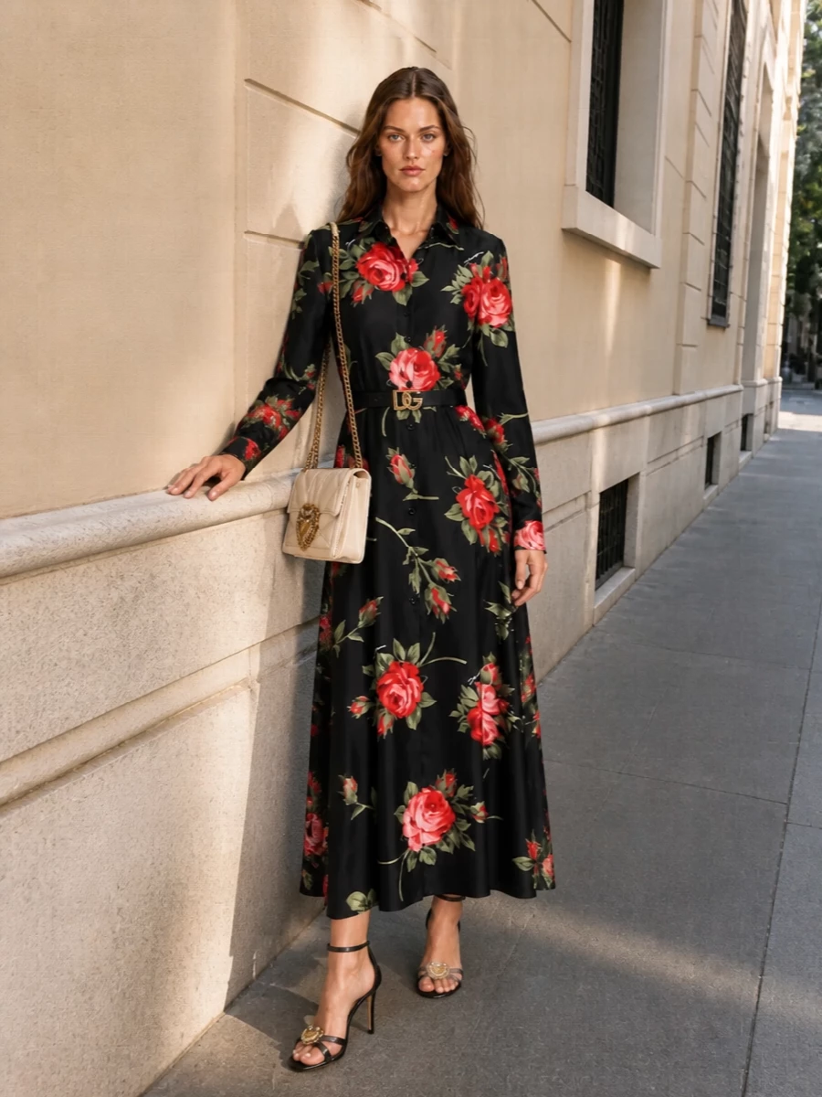Dolce & Gabbana’s rose maxi becomes pure terrace glamour when cinched with a jeweled black belt and finished with delicate black crystal sandals. A cream Devotion bag softens the black and red, keeping the mood romantic rather than severe while still polished enough for cocktail hours and gallery nights. The result is long, liquid florals framed by just a few sharp, glowing accents.