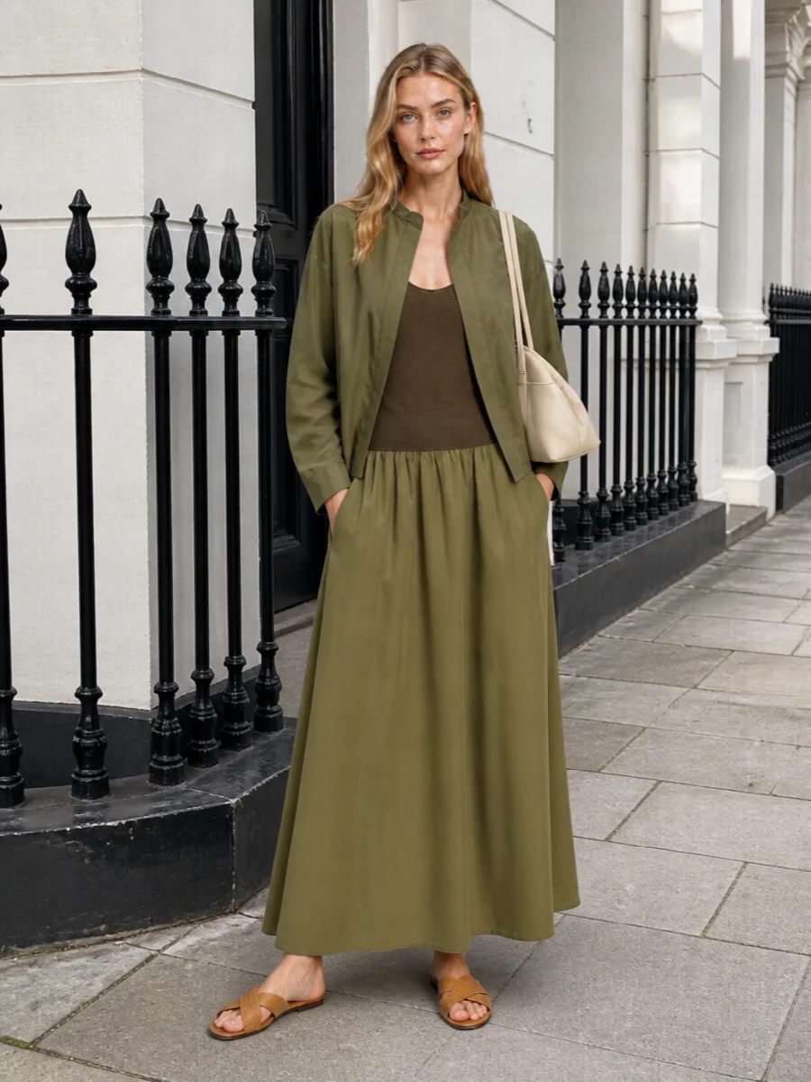 Earthy olive and buttercream keep this tank dress grounded in a soft, neutral story that feels modern and understated. Flat tan slides keep the long, gathered skirt casual but considered, while the structured shoulder bag adds a discreet, polished counterpoint. The result is quietly luxe warm weather dressing that moves easily from brunch to late-afternoon gallery visits without a change of accessories.