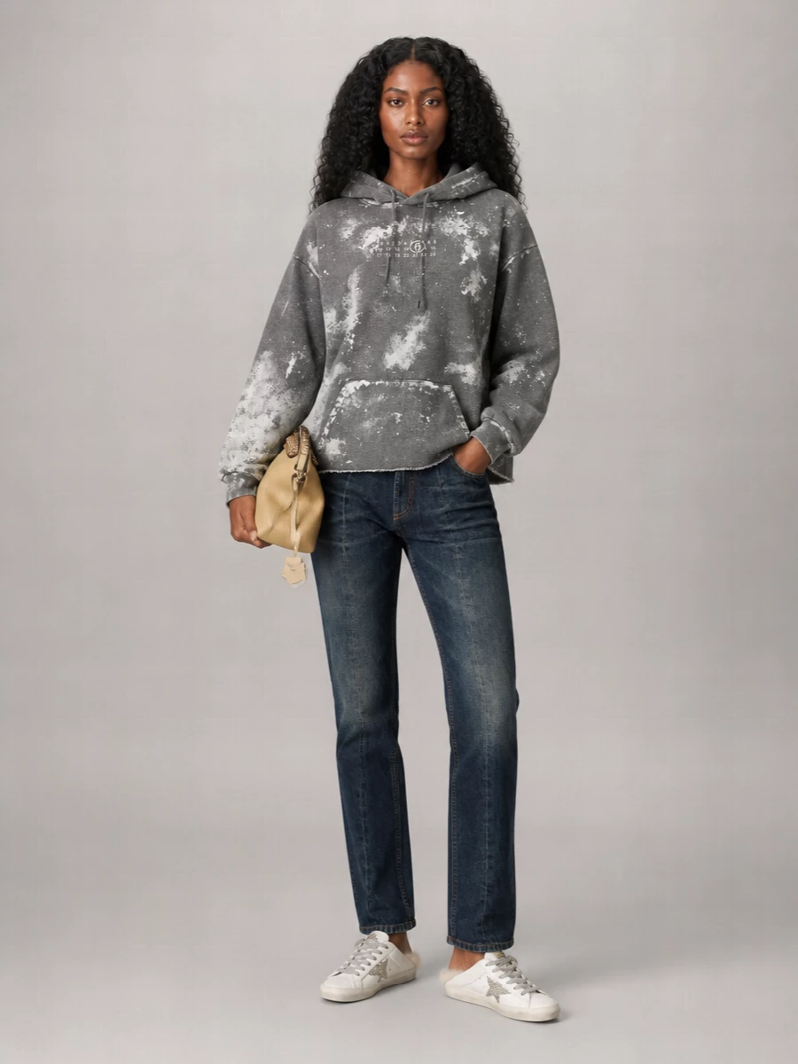 This is a relaxed, Italian-inflected streetwear set built around the shearling Golden Goose mules, with the art-splattered Mm6 hoodie and straight dark Versace denim keeping it graphic but wearable. The proportions stay easy and nonchalant, with the wide hoodie volume tapering into clean straight legs so the backless sneakers still read purposeful rather than sloppy. A stud-detailed Fendi pouch in soft beige nods to the shearling and silver glitter, giving just enough polish for city days without losing that off-duty attitude. I chose the top-and-denim route over a dress to mirror the sneakers’ off-duty DNA and keep the whole silhouette grounded in relaxed sportiness.