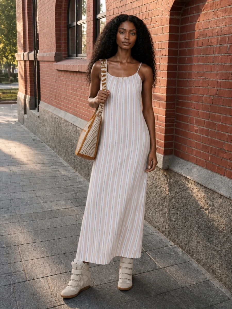 I chose the dress route to let the sneakers lengthen the line of a single, easy column rather than compete with heavy tailoring. The striped Semicouture maxi and woven Stella bucket sit in the same sun-faded neutral story, giving a soft, beach-to-city energy that still feels considered. It is relaxed, leggy and a little boho, with the wedge sneaker keeping everything grounded and urban.