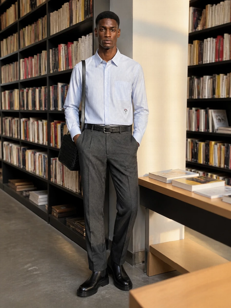 An ice-blue striped shirt sits cleanly against charcoal melange tailoring, giving you a precise but relaxed boardroom-to-dinner uniform. Black Chelsea boots and a structured intrecciato bag sharpen the line, keeping the palette cool and minimal. The result is quietly expressive, with subtle texture doing the work instead of loud details.