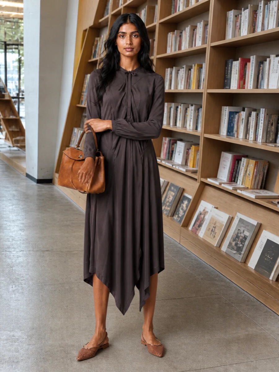 This pairing leans into soft, architectural drape against grounded leather accents, letting the Lemaire dress carry the silhouette while the Balenciaga bag provides structure. The earthy charcoal-brown and cognac tones read quietly luxurious, ideal for art openings, dinners or any refined setting where you want presence without sharp suiting. Opting for the dress route keeps the mood fluid and modern, rather than breaking the line with separate tailoring.