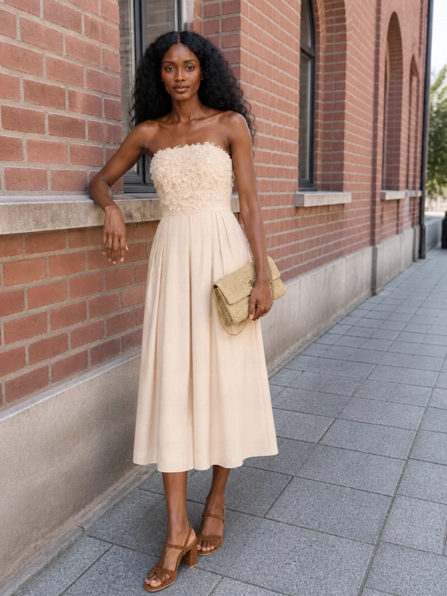 I chose the dress route to let one sculpted, romantic piece carry the story with the raffia clutch, keeping the mood fluid and feminine rather than broken into separates. The champagne strapless midi with floral detailing mirrors the bag’s softness and light while the chestnut block-heel sandal grounds the palette in warm, sunlit neutrals. Together they feel made for garden weddings or terrace cocktails, where movement, subtle shimmer and ease matter as much as polish.