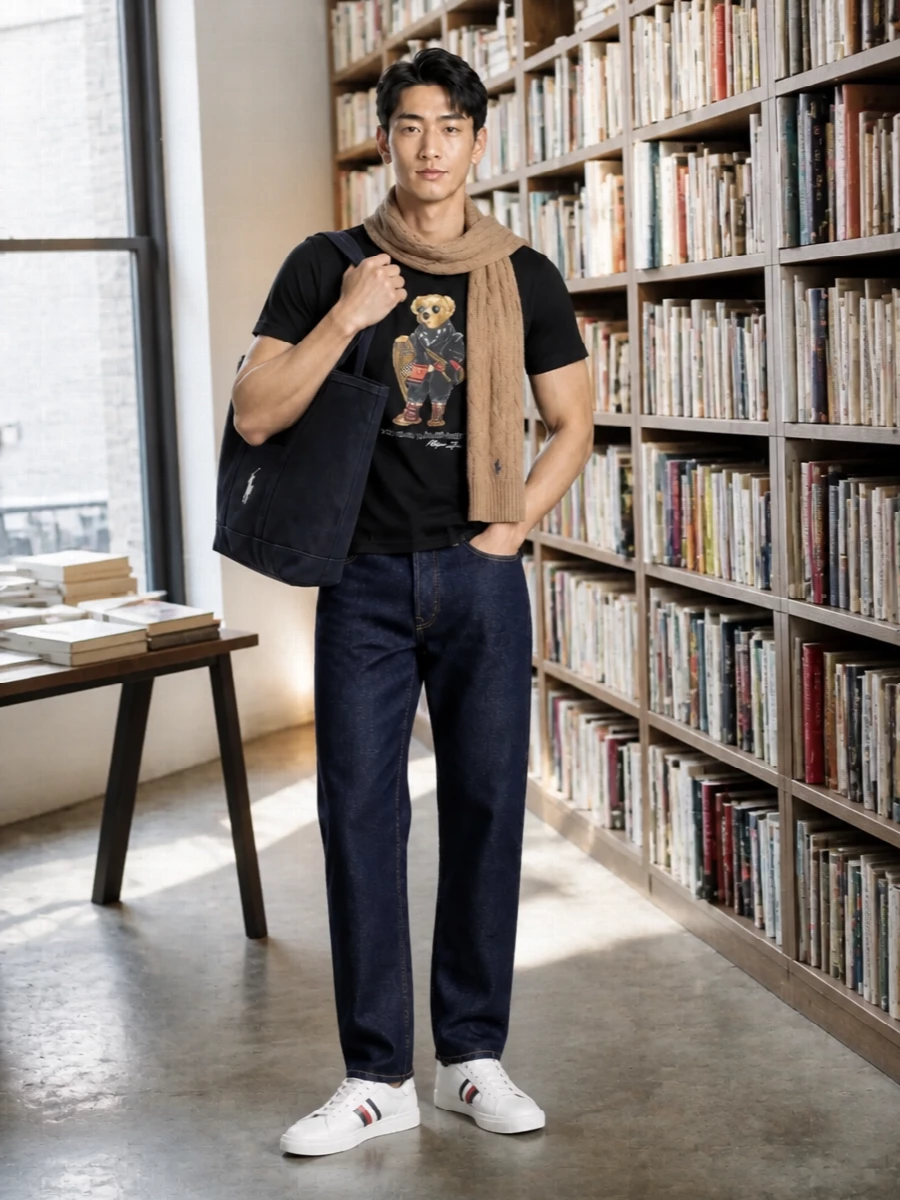 A black Polo Bear tee meets dark indigo straight denim for a clean, collegiate take on streetwear. Off white, navy striped sneakers and a navy canvas tote keep the palette sharp and sporty. A camel cable-knit scarf lifts the bear’s warmer tones and adds just enough winter texture to feel intentional, not fussy.