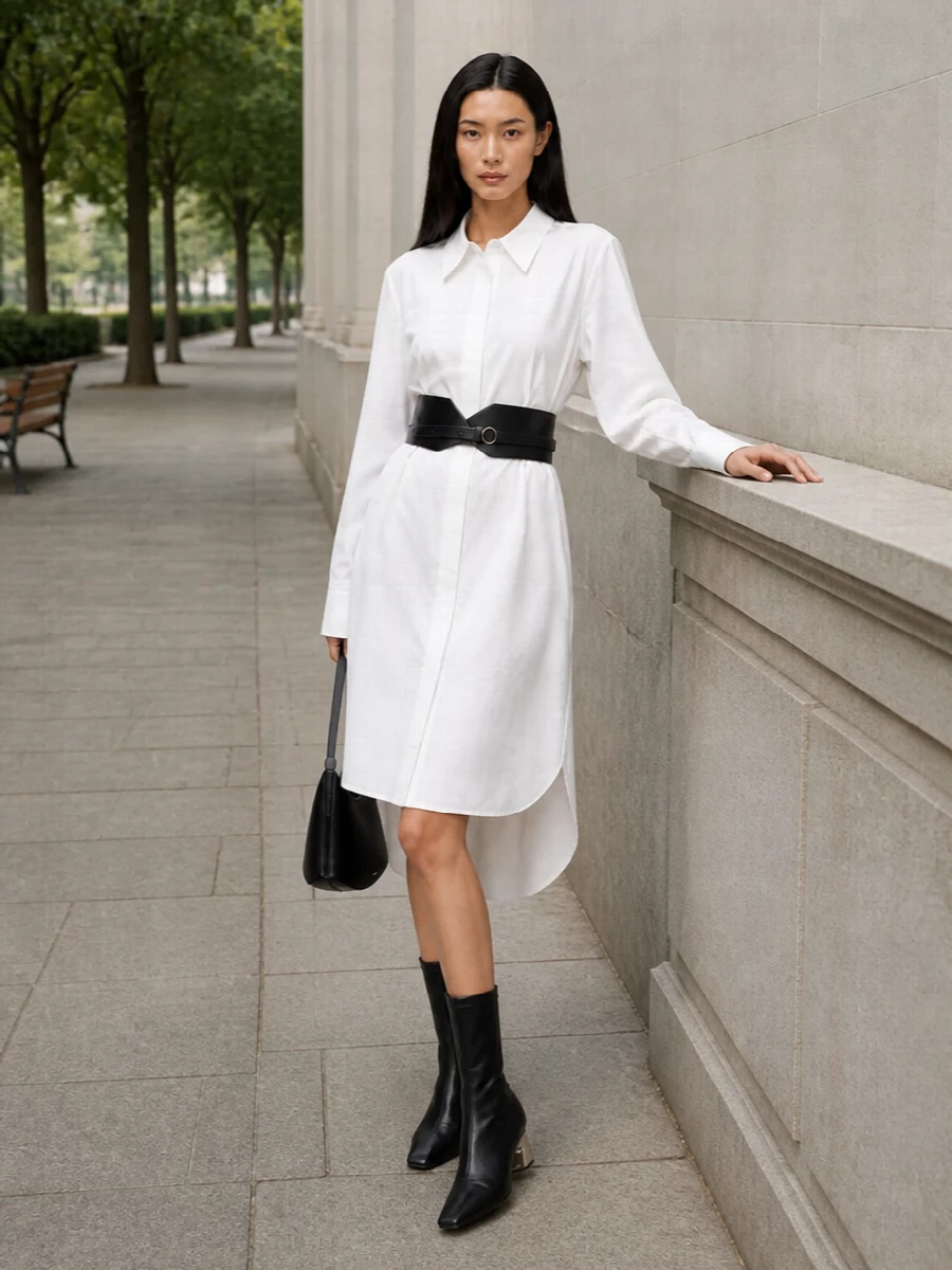 Cinch the crisp white shirt dress with the sculpted black waist belt to turn its easy volume into a long, clean line. Black pointed sock boots and a structured crescent bag ground the palette and add just enough edge for both meetings and late dinners. The result is calm, architectural dressing that feels considered without trying too hard.