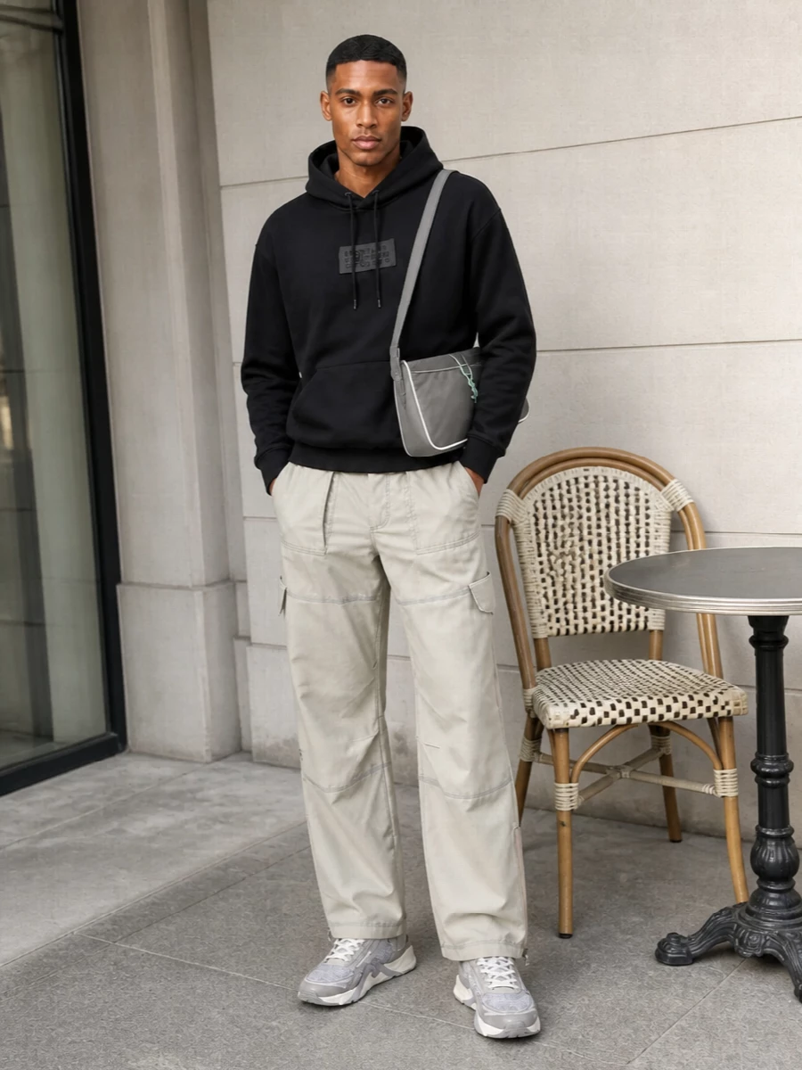 A black Margiela hoodie tops stone Acne cargo pants for a street-driven, tech-utility base that lets the sculpted Fendi sneakers stay in focus. The grey Saint Laurent shoulder bag quietly echoes the footwear’s technical palette while adding a soft graphic accent at the hip.
