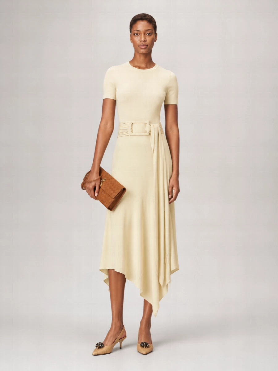 Alaïa’s buttercream knit midi and the caramel Bottega clutch create a quietly luxurious evening story in soft, tonal neutrals. The sculpted belt and asymmetric hem give just enough movement, while the caramel Valentino slingbacks echo the bag’s warmth and gold accents for a cohesive, polished finish. Choosing the dress route keeps the message minimal and focused, letting cut and texture do the work rather than extra tailoring separates.