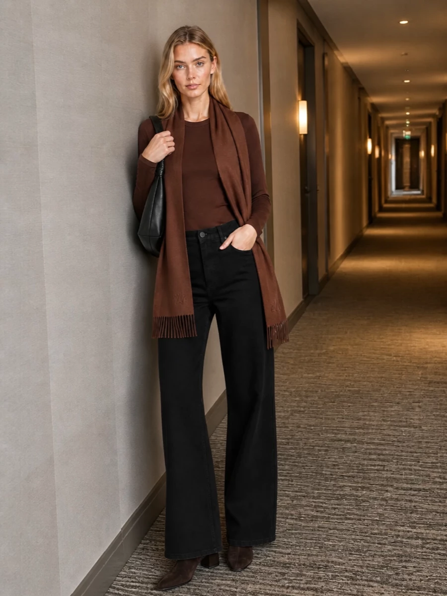 Deep chocolate and inky black create a long, composed line, with the fitted tee tucked into fluid wide-leg trousers for a clean, modern proportion. Square-toe suede boots and a sculpted hobo bag keep everything grounded and minimal, while the chestnut scarf adds just enough warmth and softness for cooler days. The result is a calm, city-ready uniform that feels precise without being stiff.