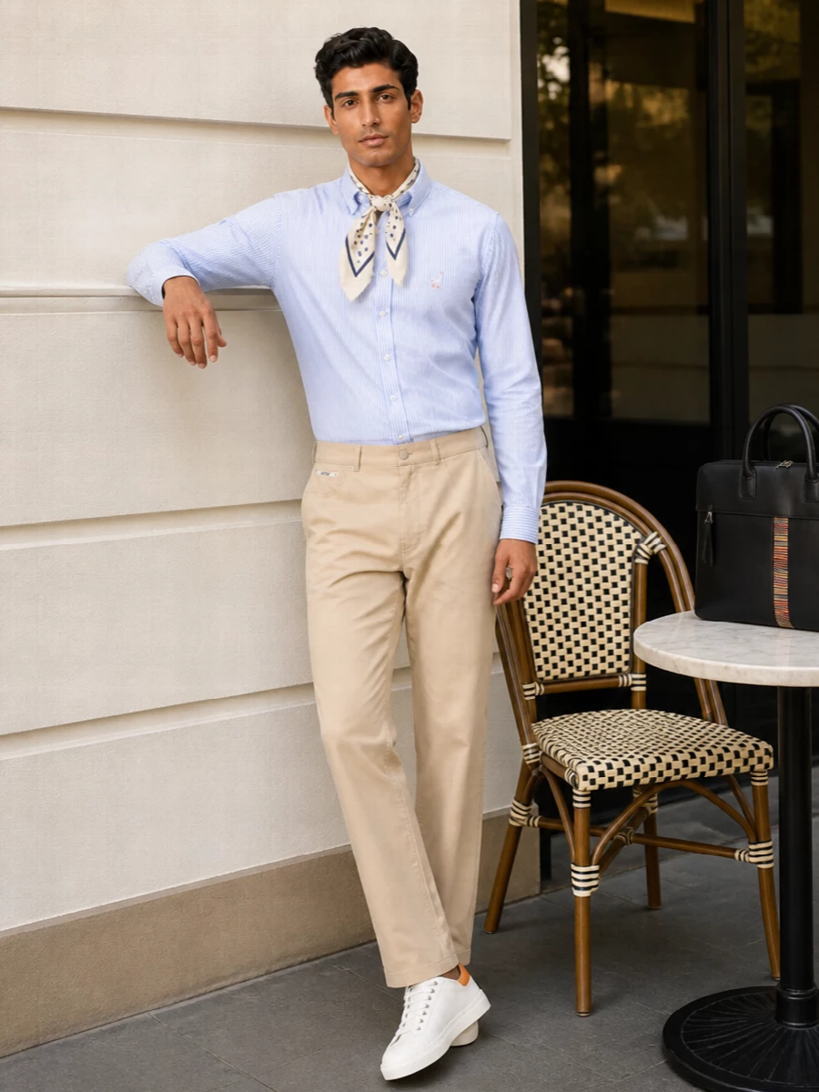 A crisp striped Moschino shirt meets clean beige tailoring for a smart summer take on classic office dressing. Off-white sneakers and a structured briefcase keep the mood modern and mobile, precise enough for meetings yet easy for city days. A dotted silk scarf quietly ties the navy accents together without ever feeling fussy.