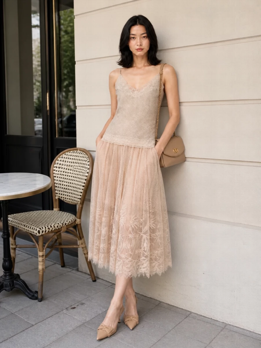 A stone lace camisole and blush tulle midi skirt create a soft, romantic column in the warmest neutrals. Nude slingbacks and a matching flap bag refine the textures, shifting the lingerie-inflected pieces into a quietly sensual dinner ensemble. The result is intimate, fluid and polished without losing that whisper-light ease.