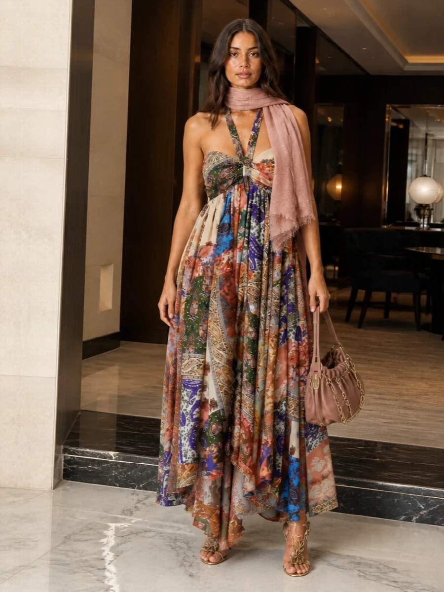 A romantic Zimmermann maxi takes center stage, its swirling paisley and open back grounded by warm metallic sandals and a softly ruched rose-tan shoulder bag. The dusty rose stole is there when the evening cools, adding just enough shimmer and warmth without crowding the print. It is an elegant choice for garden weddings, rooftop cocktails or any late-summer night you want to feel cinematic yet relaxed.