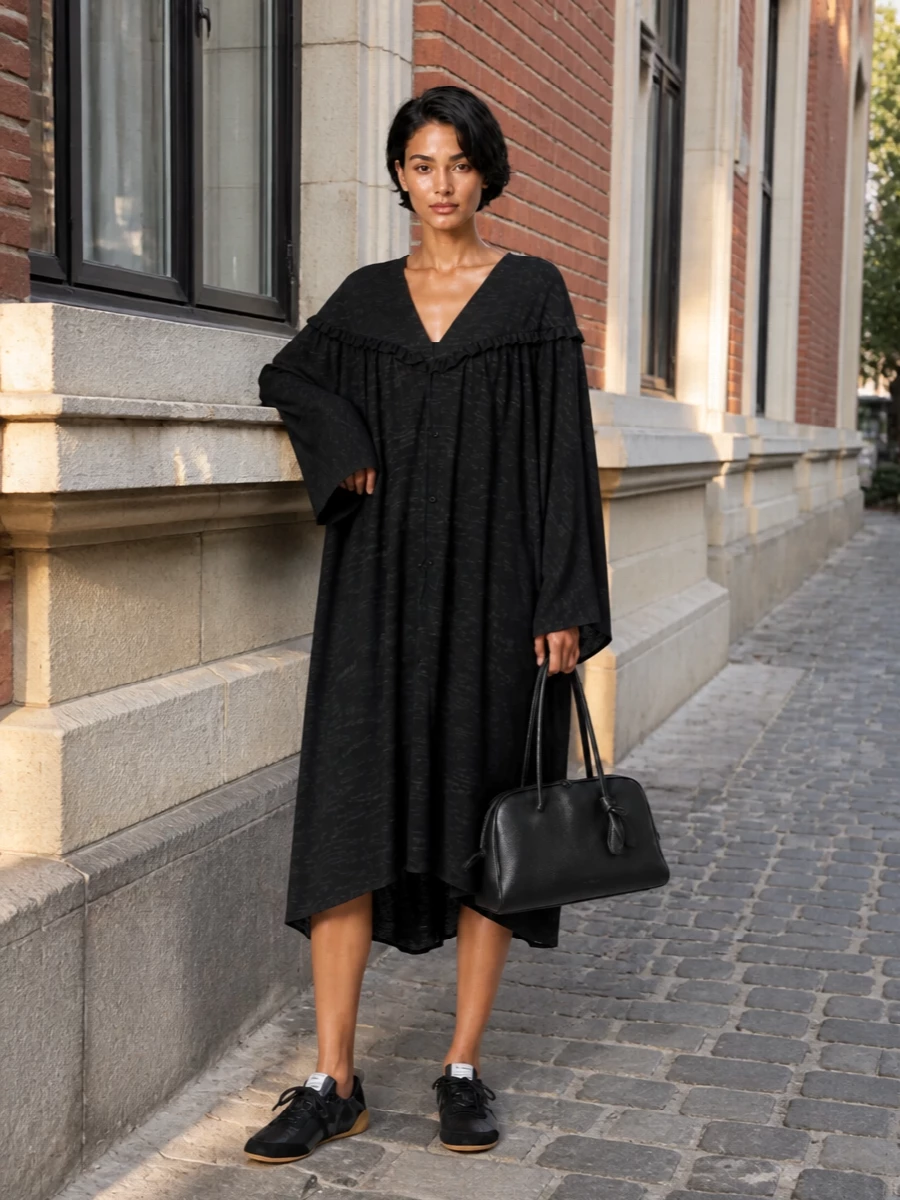 Leaning into the sneakers’ understated sport mood, the washed-black draped midi dress keeps everything relaxed yet considered, with movement that plays nicely against the low-profile gum sole. The black Jacquemus tote reinforces the monochrome story and quiet luxury attitude, so the trainers read intentional rather than purely casual. I chose the dress route instead of separates to keep the silhouette clean and artful around the statement sneaker, avoiding any clash between tailored trousers and the soft, ballet-inspired shape of the shoe.