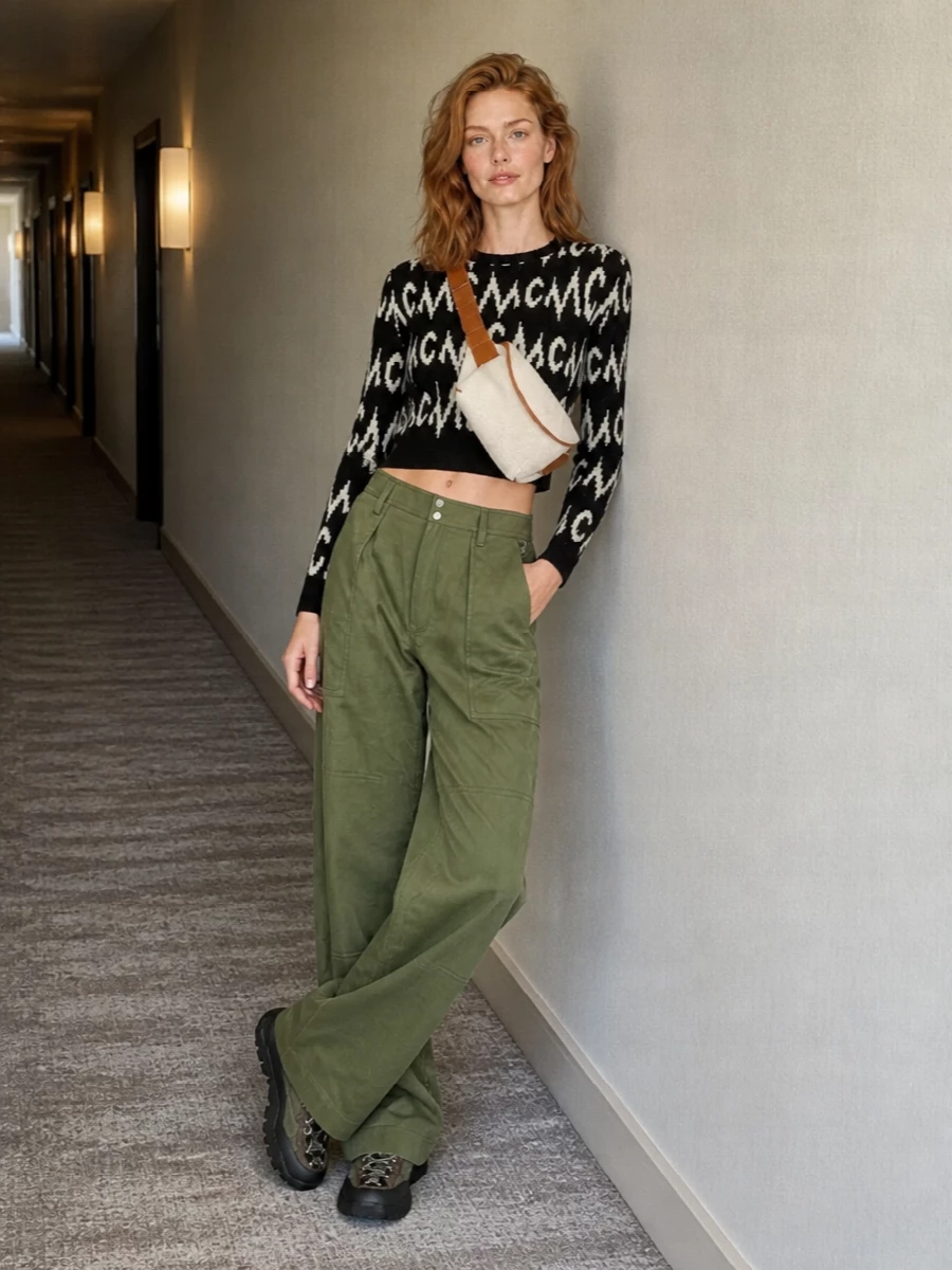 Graphic streetwear meets utility here: the cropped MCM monogram knit slices cleanly against Paco Rabanne’s architectural olive cargos and those trek-inspired Miu Miu sneakers. The palette stays tight in black, ivory and olive, so the proportions and textures do the talking while the belt bag pulls everything into a hands-free, city-ready stance.