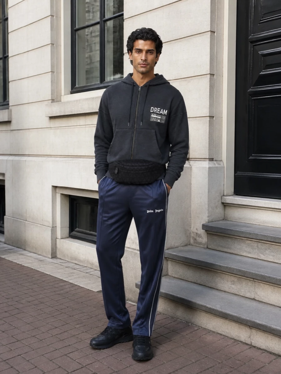 Charcoal, navy and black keep this set tight and graphic, so the hoodie’s print can do the talking. The Palm Angels track pant and Valentino runners lock in a clean sport profile, while the belt bag adds low-key logo attitude without cluttering the lines. Built for city days where comfort still needs a point of view.