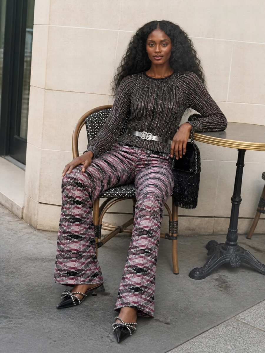 Missoni’s pink and black flares meet a sequinned knit top for a high-shine, pattern-on-pattern evening ensemble that still feels considered rather than chaotic. Crystal-strapped kitten mules, a fringed sequin mini bag and a mirrored belt pull the black and silver accents through, keeping the silhouette long and lean while the textures do the talking.