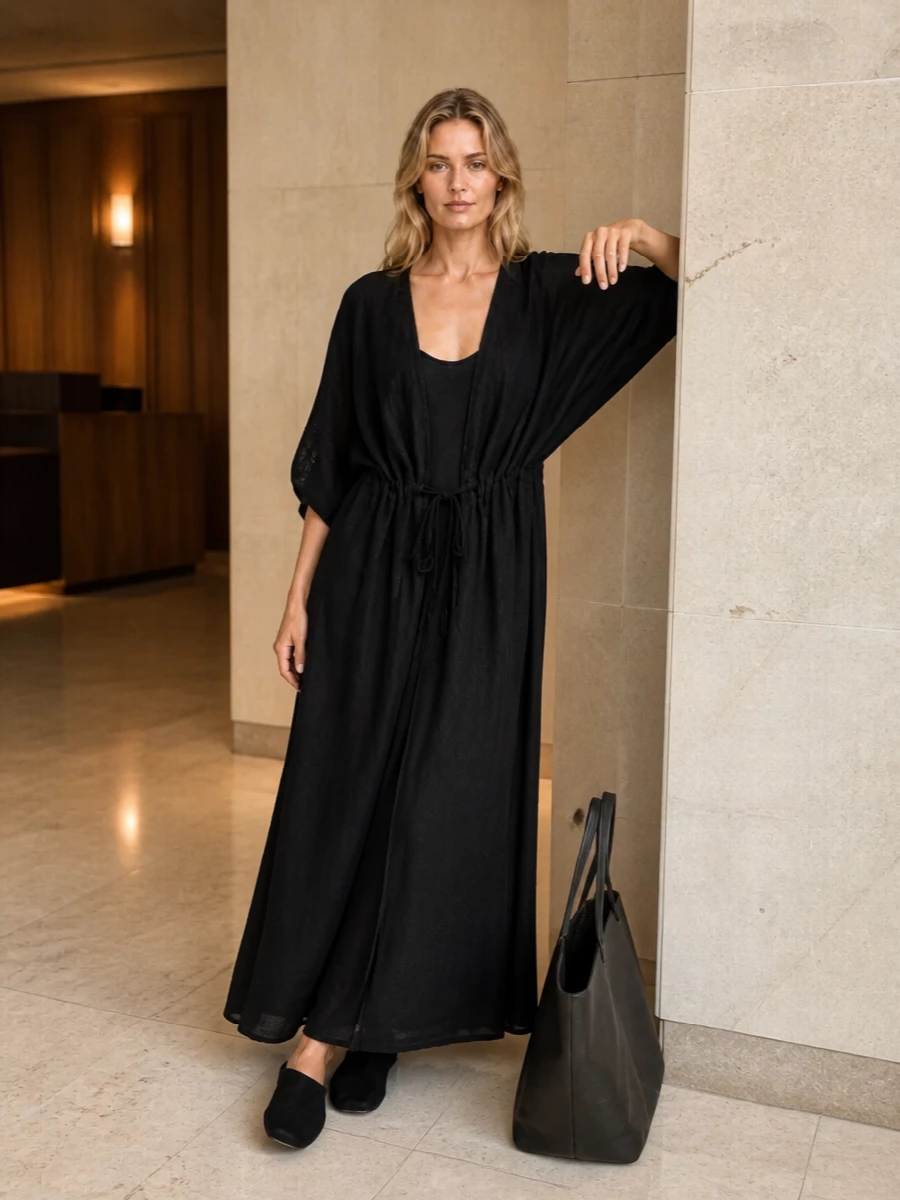 This is all about a black-on-black Uma Wang column, the slip dress disappearing under the robe so the drama comes from movement and texture rather than contrast. Faux-fur mules keep it grounded in cocooned, at-home ease, while The Row tote lets the whole ensemble step quietly into the city without breaking the serenity. I chose the dress path over separates to preserve that uninterrupted vertical line the robe wants, keeping the silhouette long, fluid and almost meditative.