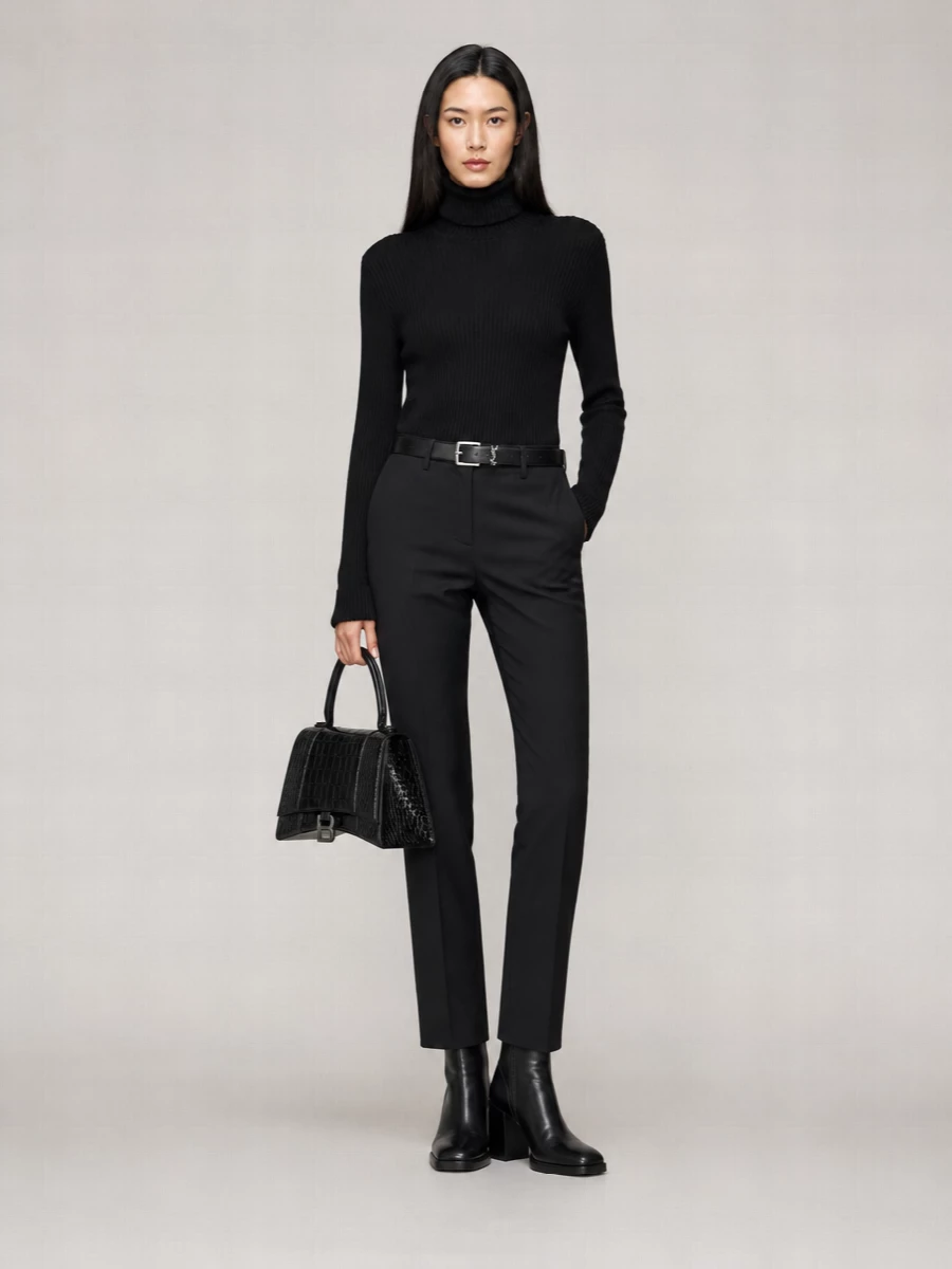 A fully monochrome take on quiet luxury, this pairing leans into clean lines and immaculate tailoring. The close-fitting turtleneck and slim black trouser create a continuous column, subtly defined at the waist. Textured leather accessories and a solid-heeled boot keep the finish refined and city ready without ever feeling over-styled.