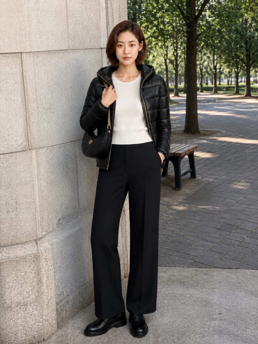 This is a clean monochrome city composition built around the Herno puffer, with an ivory knit brightening the face and black tailoring slimming the line. I chose the top and trouser route rather than a dress to respect the jacket’s sporty everyday character and create a versatile day-to-dinner uniform. Wide-leg suiting, solid derbies and a compact quilted shoulder bag keep it quietly luxurious but fully practical across seasons.