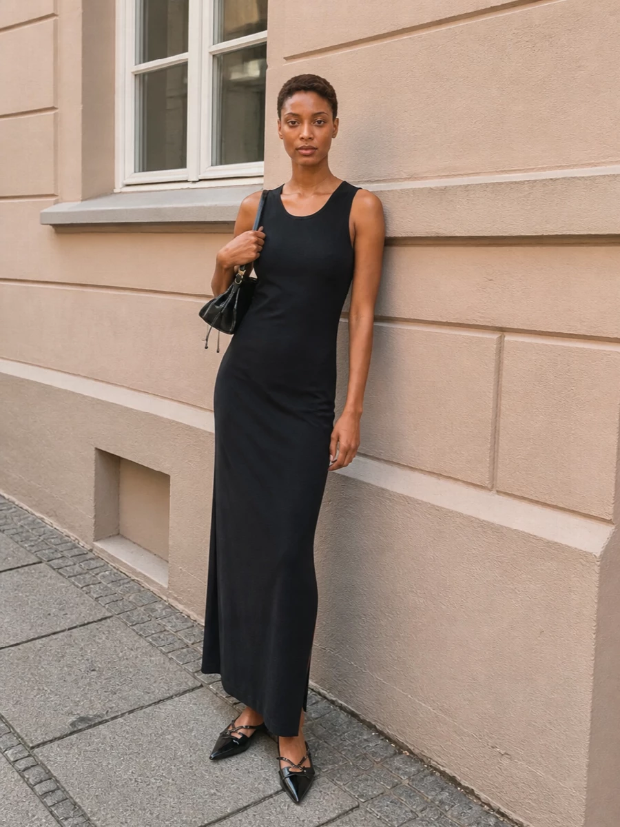 I am building around the dress path, because a single immaculate black sheath harmonises best with the Prada bag’s sleek formality and keeps the silhouette pure and uninterrupted. The Balenciaga maxi creates a long, architectural line, while the pointed Miu Miu slingback flats keep it sharp yet understated so the focus stays on cut and proportion rather than obvious branding. The result is a quietly powerful evening ensemble in deep black tones that moves easily from intimate dinners to late gallery nights with the bag as the discreet, polished anchor.