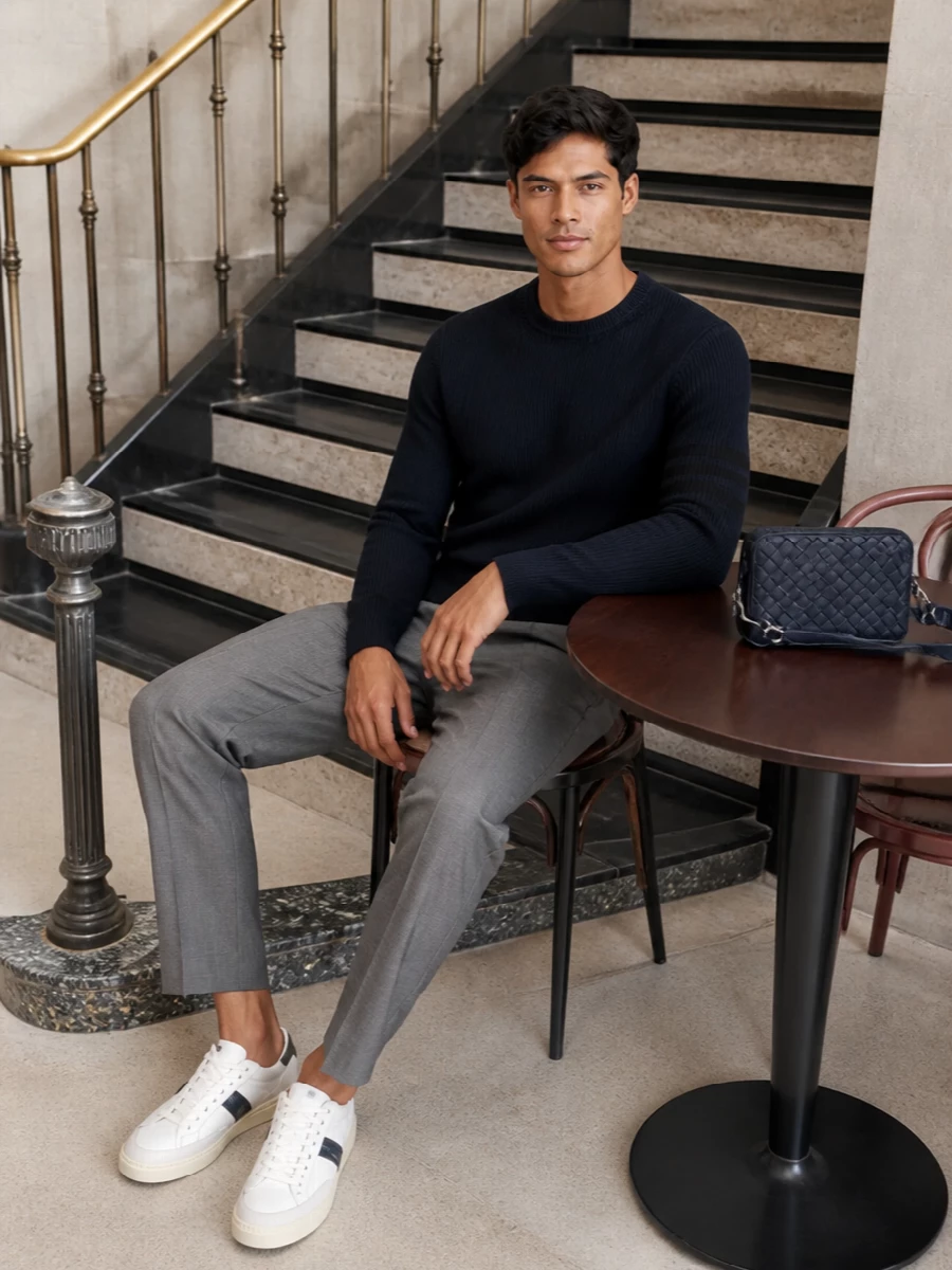 A deep navy ribbed knit sits over softly tailored grey pleats for a modern, preppy take on city polish. Clean Tom Ford sneakers keep it relaxed, while a navy Bottega crossbody adds discreet structure and texture. The palette stays firmly in the navy and grey family, giving a calm, high-tier finish that moves easily from desk to dinner.