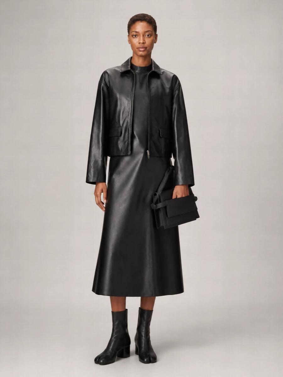 I’m anchoring everything around the Marni leather jacket’s glossy minimalism, so the sculpted black A-line dress is the most coherent partner, giving you a strong, architectural column under the cropped leather. Sleek Margiela ankle boots keep the line sharp but wearable for city evenings, while the compact trapeze bag quietly echoes the geometry without competing. The result is a dark, streamlined Marni-heavy ensemble that feels confident and precise rather than over-styled.