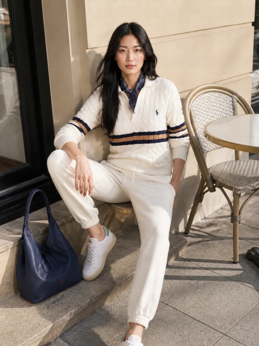 A softly tonal take on sport-preppy, where an ivory jogger pairs with the collared sweatshirt for a clean, almost monochrome base. Navy leather and paisley accents bring just enough structure and heritage to keep the set feeling considered rather than gym-bound. The result is relaxed, coastal-weekend polish that still reads put together for coffee runs or casual city days.