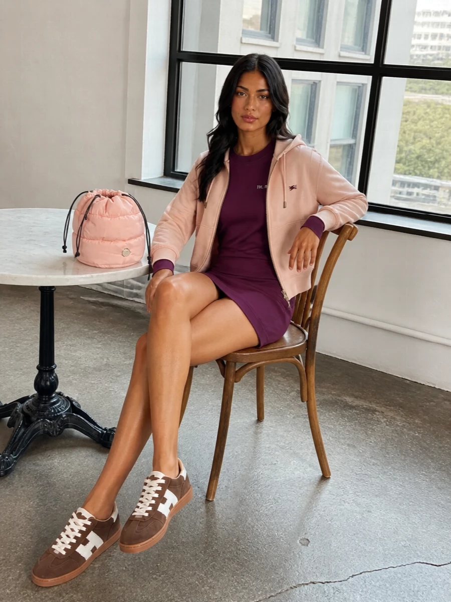 I chose the dress path, pairing the Burberry blush hoodie with a sweatshirt mini rather than denim or trousers, to keep the whole outfit relaxed, sporty and streamlined without competing waistbands. The Attico’s plum dress shifts the palette into richer FW territory, while chocolate sneakers and a blush padded bag pick up the hoodie’s warmth for a cohesive, quietly playful streetwear ensemble. It feels like an off-duty city uniform that is comfy enough for all day but considered enough for brunch or casual dinners.