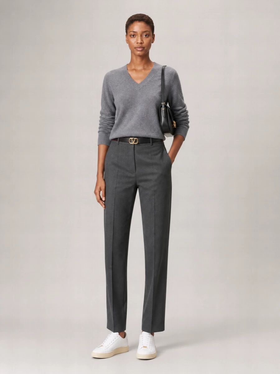 Slate-grey knit meets charcoal suiting for a quietly refined take on off-duty tailoring. Straight-leg trousers and a structured black shoulder bag keep the lines clean, while low-key court sneakers relax the mood. The slim VLogo belt adds just enough definition to frame the soft V-neck without disturbing the calm palette.