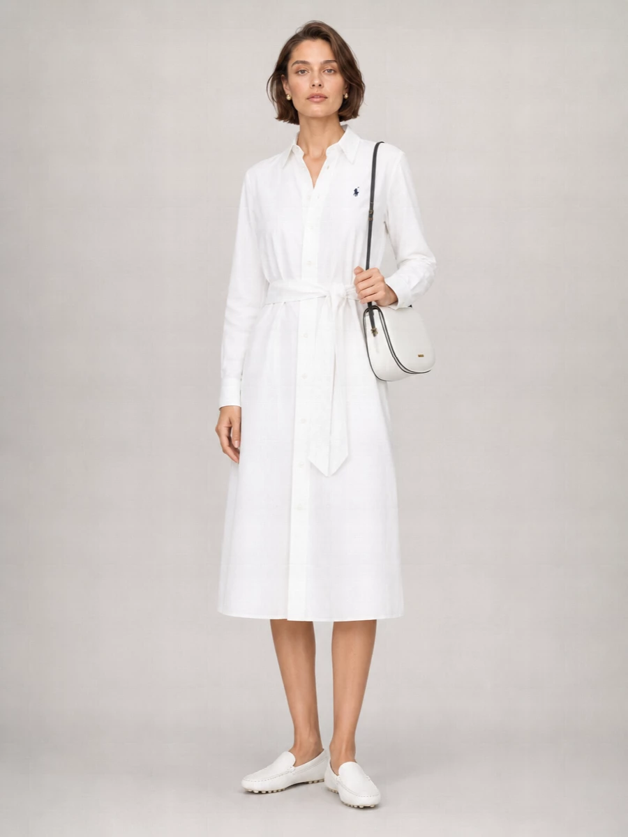 Crisp and collegiate, this pairing leans into the shirt dress’s clean lines with white leather loafers that feel polished yet easy on the move. A soft white shoulder bag with black trim adds just enough contrast, while a tan leather belt and tiny pearl studs keep the finish subtle and considered. It is an ideal city-day uniform that moves smoothly from coffee runs to casual meetings without ever feeling overstyled.
