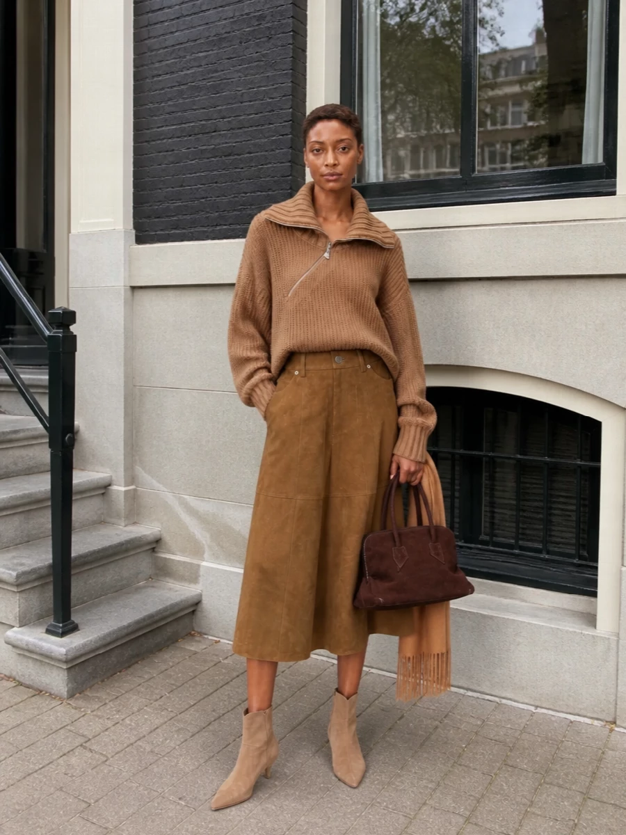 A cocooning camel half-zip meets a supple A-line midi for a tonal city uniform that feels relaxed but unmistakably considered. The pointed suede ankle boots and structured dark-chocolate mini tote bring just enough definition, keeping the silhouette long, lean and quietly luxurious. A soft camel scarf finishes the palette with subtle depth and warmth.