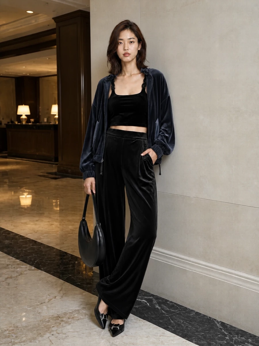 I’m building this around the bomber as a night-out hero, so a TOP plus BOTTOM route makes more sense than hiding it over a dress. Velvet on velvet with the crop top and wide-leg trousers gives a rich, monochrome foundation that feels modern rather than fussy. Pointed kitten heels and a curved black hobo keep everything sharp enough for dinner and drinks while still reading relaxed and urban.