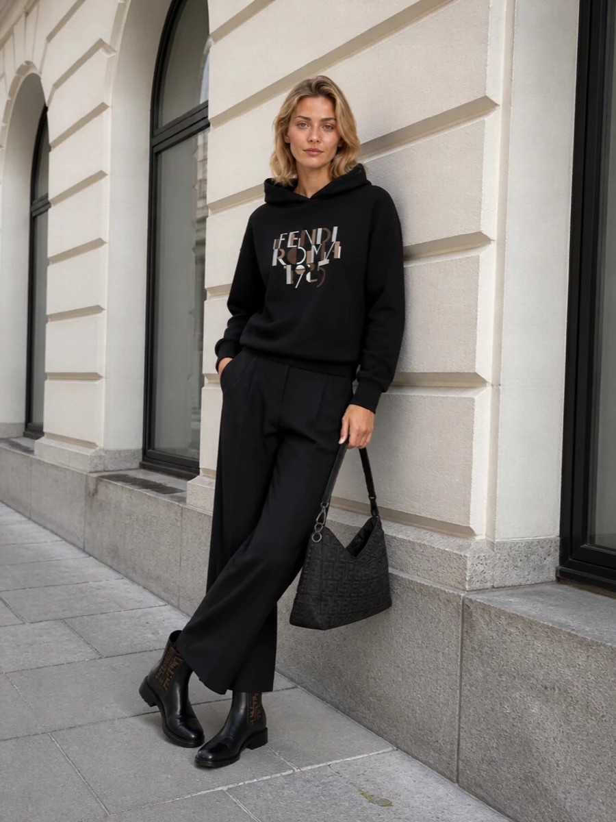 This is quiet Fendi streetwear, grounded in black with just enough logo to feel intentional. The hoodie and wide-leg trouser play with volume over the structured Chelsea boots, keeping the line long but relaxed. It’s the kind of city uniform that reads polished in monochrome, but still feels like you could walk all day in it.