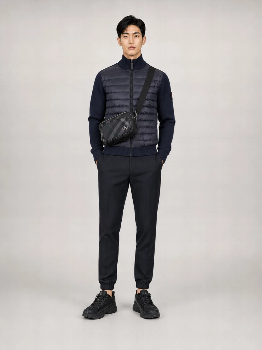 A navy quilted knit sits against sharply tapered jogger-style trousers for a city-ready take on technical comfort. Black runners keep the lines streamlined and athletic, while the charcoal crossbody introduces discreet structure and just enough logo to feel considered rather than loud.