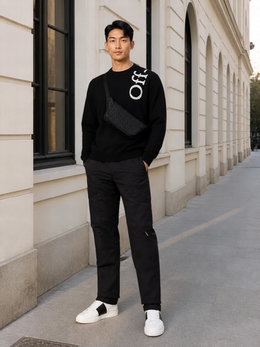 Off-White’s graphic crew sits over black Comme des Garçons straight-legs for a clean, utilitarian take on streetwear in a strictly monochrome palette. Valentino’s crisp white-and-black sneakers keep the line sharp and modern, while the slim Bottega crossbody adds quiet texture without disturbing the minimal mood. The result is a calm, city-ready uniform that feels considered but not over-styled.