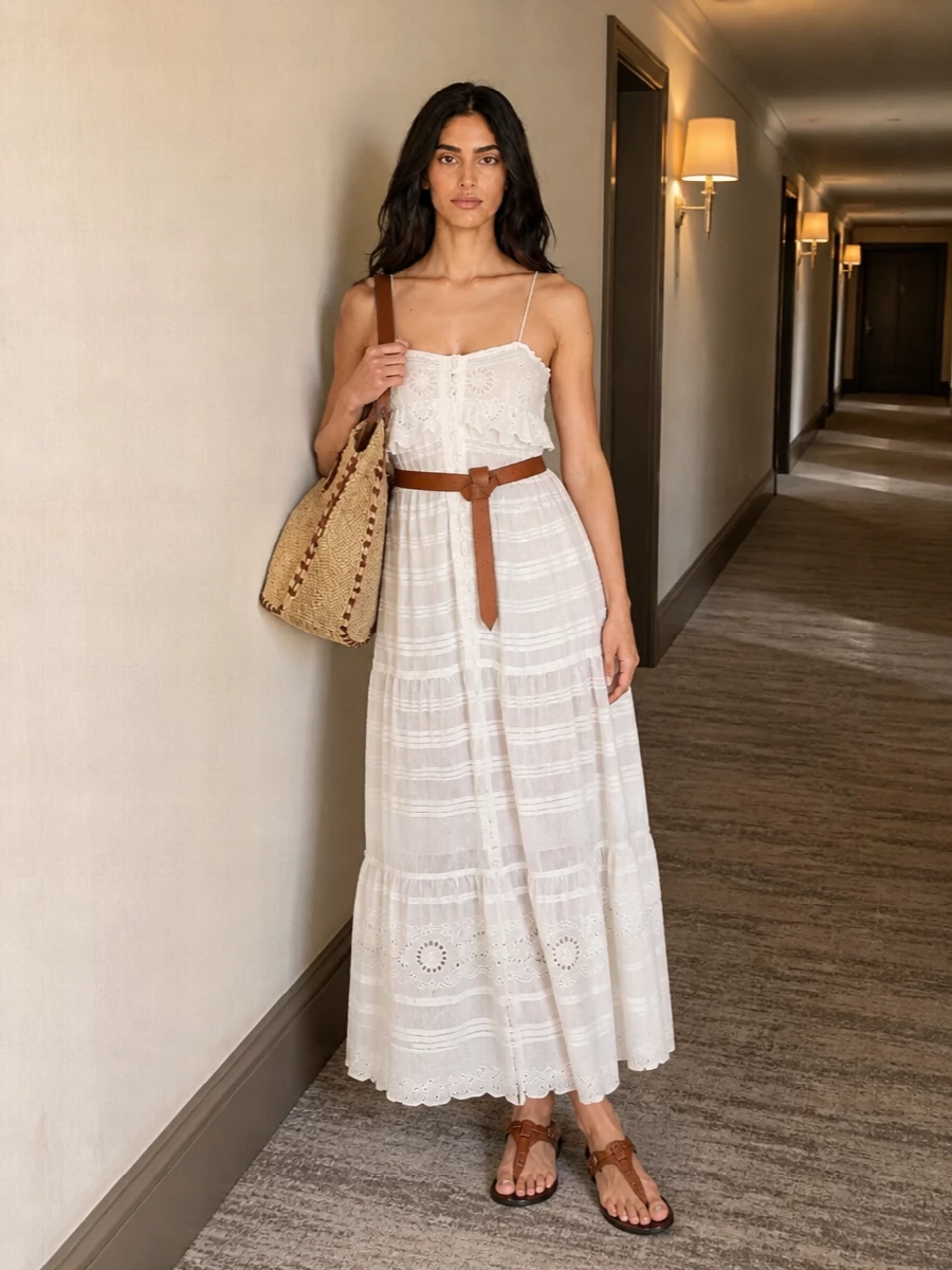 Sheer tiers and sunlit crochet stay soft and romantic, grounded by bare, taupe leather straps at the feet. A woven raffia and tan tote and a simple knotted belt bring just enough structure, keeping the whole outfit relaxed, bohemian and ready for long summer days from coastal walks to garden lunches.