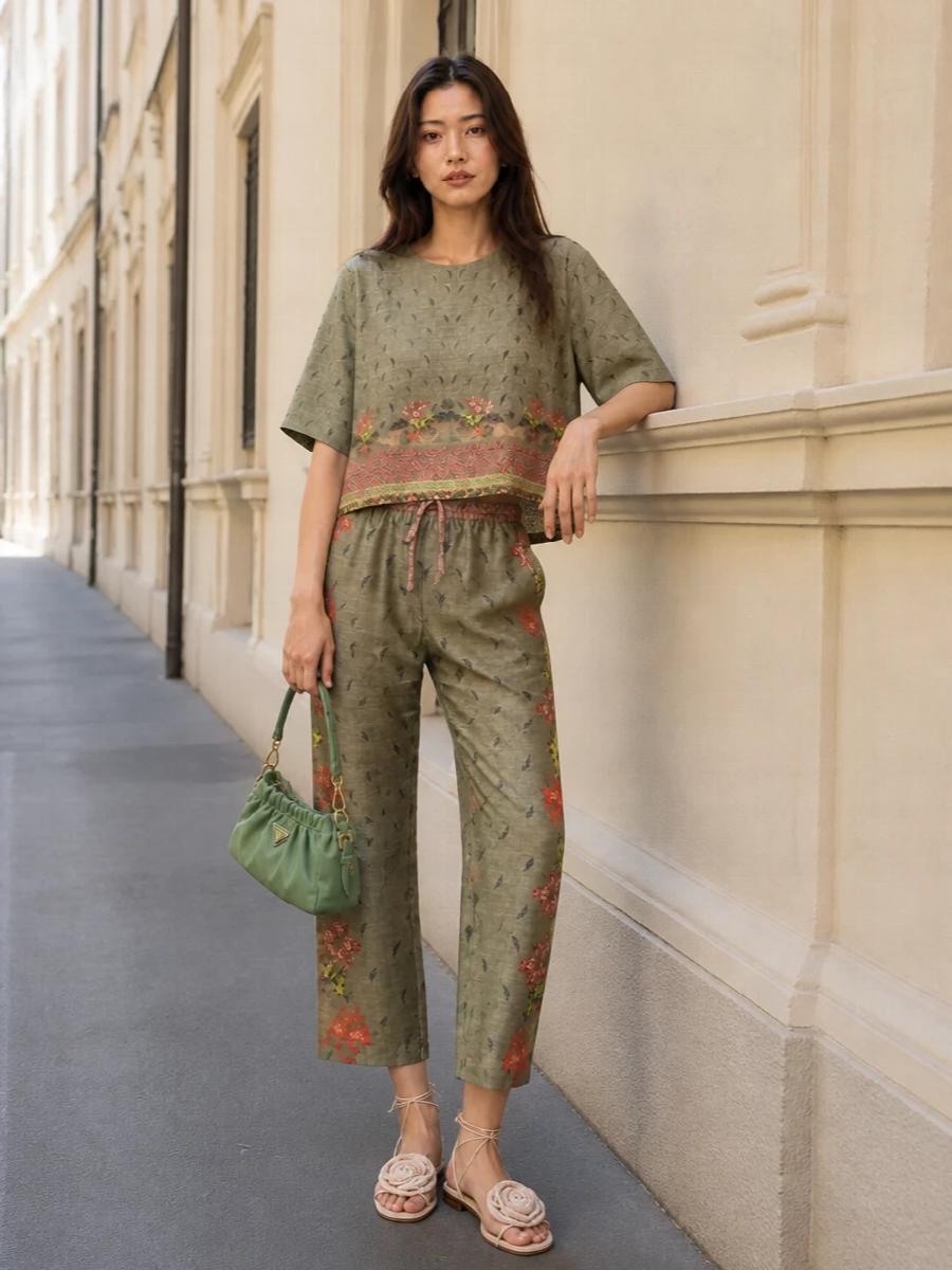 A softly romantic Pierre Louis Mascia set that layers sage and olive florals in relaxed proportions, reading like an artful yet understated summer co‑ord. Neutral lace‑up flats keep the volume grounded and easy, while a matching sage Prada shoulder bag and a gauzy floral scarf pull the palette into a quiet, bohemian whole.