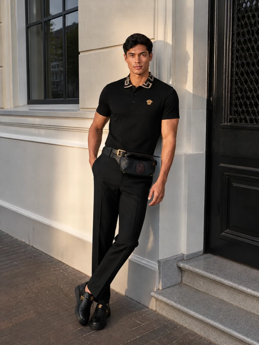 A sharp black Versace polo meets high-rise tailored trousers for a clean, elongated silhouette in pure black and gold. Black Medusa-detailed sneakers keep it grounded in the city, while a leather belt bag and slim gold-buckled belt add discreet structure and house attitude. The result is polished, confident and versatile enough for anything from gallery afternoons to late-night drinks.