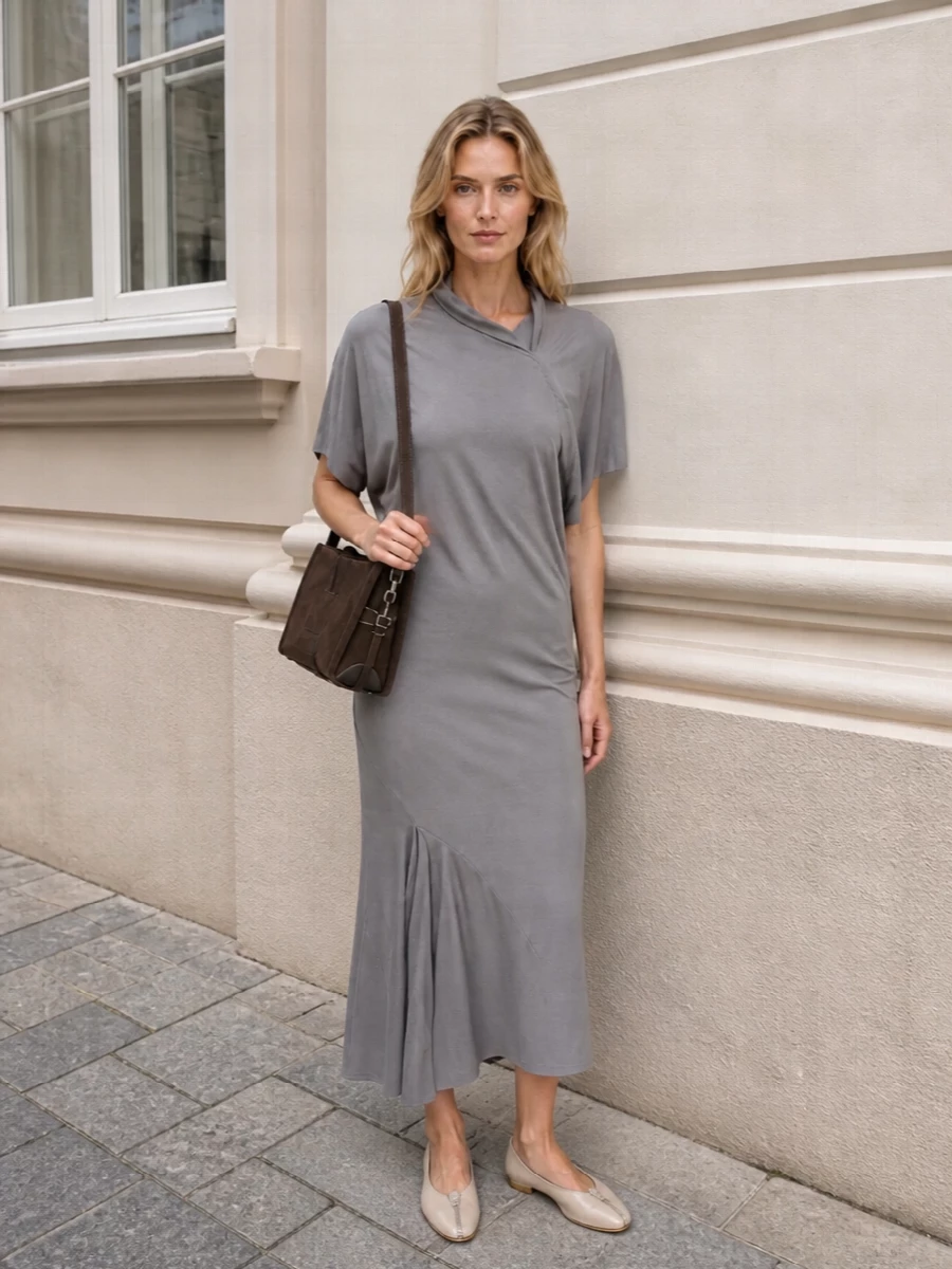 This pairing leans into a quietly directional mood by setting the sculpted Rick Owens midi against the tactile chocolate suede bag, all in a hushed grey and brown neutral story. The Burberry flats keep the line clean and grounded, so the asymmetry and drape can read as intentional rather than fussy. Choosing the dress route over separates lets the bag feel like a considered object against a single continuous silhouette, perfect for artful days that stretch into dinner.