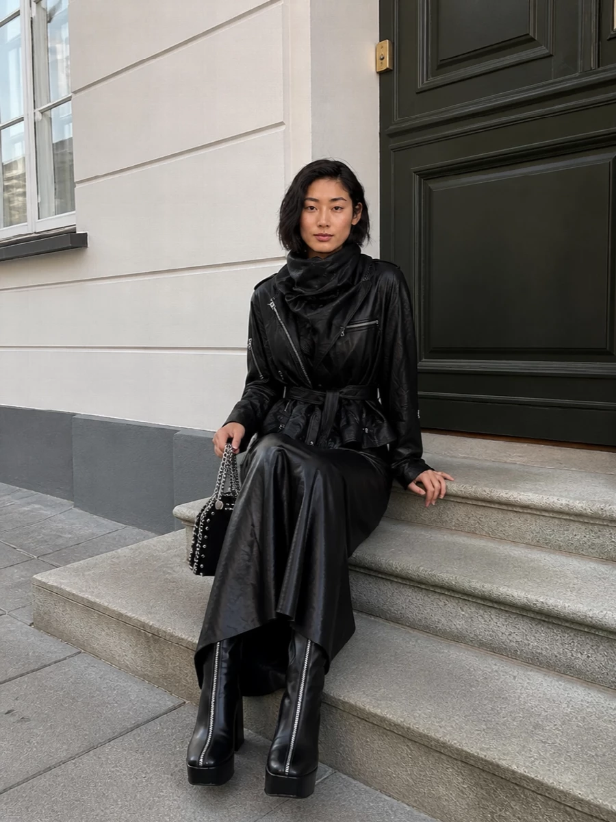 I’m taking the dress route here, building a single, uninterrupted black column under the Rick Owens moto so its asymmetric belt and hardware stay the main event. The liquid Margiela maxi and Prada platforms create a long, armored line, while the chained mini bag brings just enough metal and edge to match the jacket without tipping it into costume. It reads like nocturnal streetwear with couture control: club, gallery, or late dinner ready in one move.