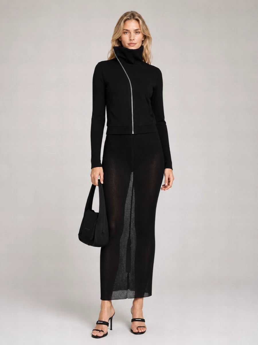A sheer black column and razor-thin mules turn this into a clean, nocturnal statement with a subtle downtown attitude. The curved shoulder bag softens the severity just enough, keeping everything monochrome and graphic. It is styled to feel intentional from gallery late nights to low-lit bars.