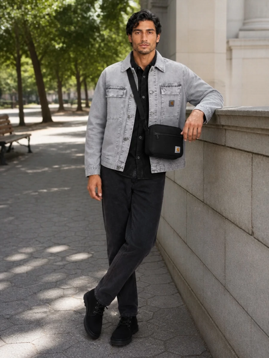 A washed grey Carhartt WIP jacket sits over black cord and denim for a tight, monochrome workwear story that feels lived-in but precise. The black Ugg chukkas and compact crossbody keep everything grounded and city-ready, adding warmth and function without breaking the calm utility palette.