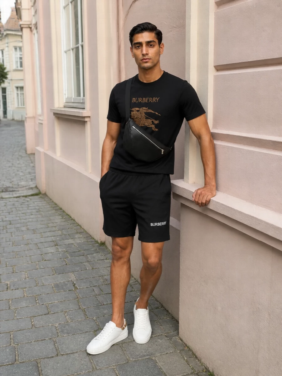 Black on black keeps the Burberry knight tee as the statement, with relaxed chino shorts giving it a clean, city-ready summer base. White leather sneakers light up the palette just enough, while the streamlined black sling adds function without breaking the graphic simplicity. The result is relaxed streetwear with a distinctly polished, logo-aware edge.