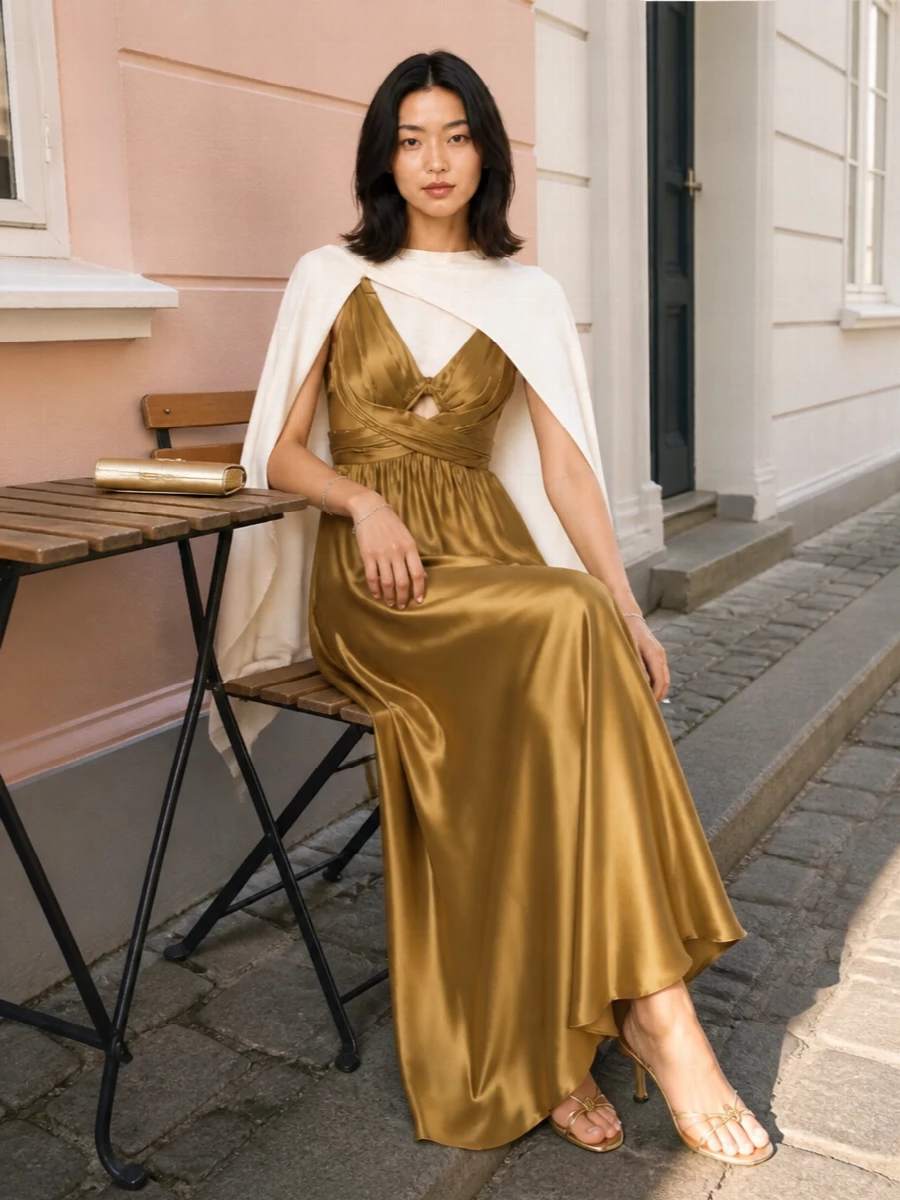 Liquid antique gold and fine metallic accents create a quietly glamorous evening ensemble with real depth. Gold sandals and a gleaming clutch echo the satin without feeling matchy, while a single pearled bracelet keeps the sparkle precise and refined. The result is a romantic, grown up take on occasion dressing that feels sensual, polished and completely considered.