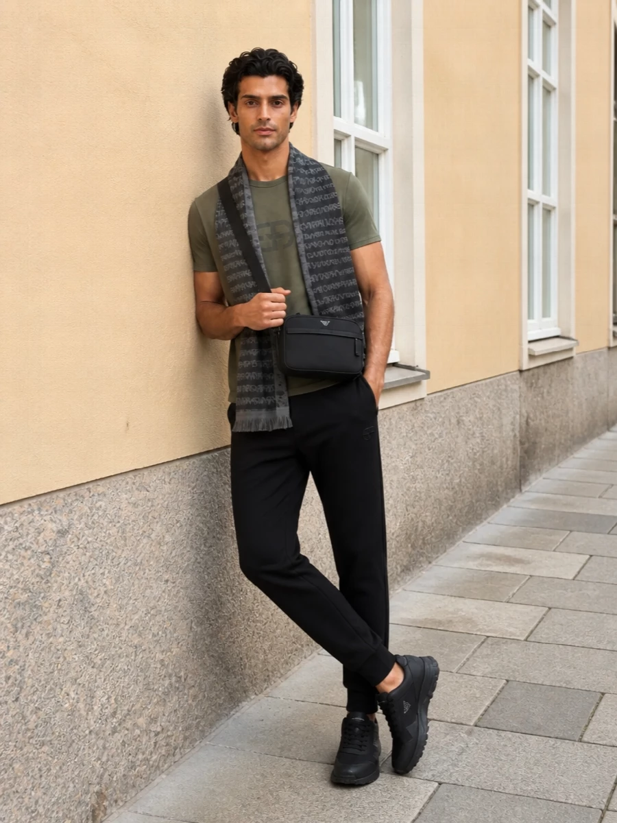 Olive, black and soft greys come together in a clean, urban mix that feels relaxed yet intentional. The tapered jogger and streamlined runners keep the silhouette sharp without trying too hard, while the crossbody and scarf add just enough structure and branding for city days on the move.