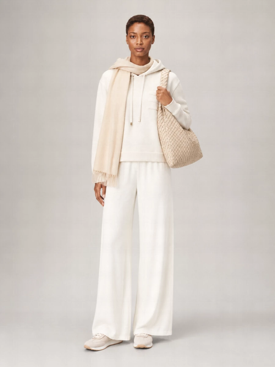 A tonal ivory and sand story keeps this hoodie set calm, polished and incredibly soft to the eye. The fluid wide-leg pant and sleek neutral runner stretch the line, so the relaxed top reads intentional rather than casual. A slouchy woven hobo and feather-light wrap add texture within the same palette, reinforcing that quiet luxury mood for travel or slow city days.