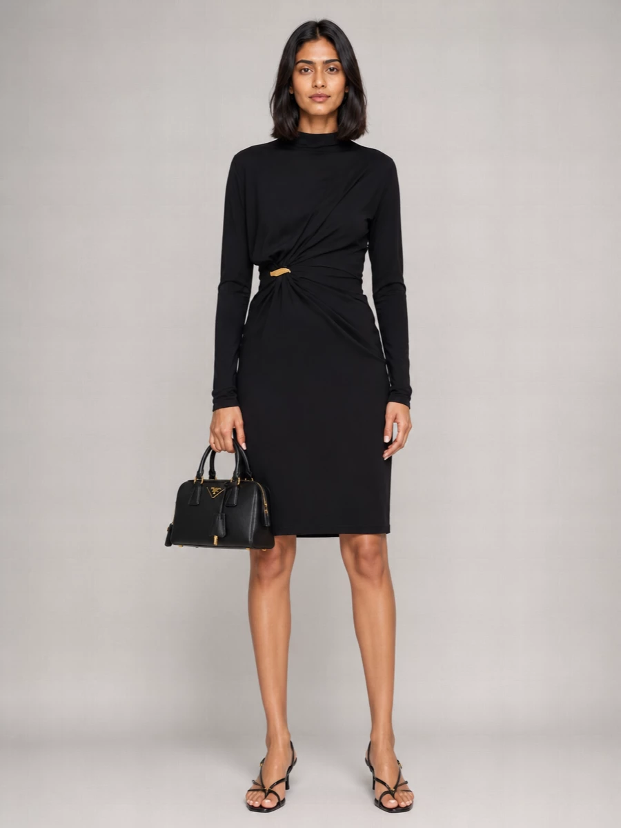 This is a distilled black-and-gold evening ensemble built around pure line and structure. The sculpted Bottega dress and slender Miu Miu slingbacks let the Prada bowler’s hardware punctuate the look without noise. Choosing the dress path keeps the message focused and formal, ideal for city cocktails or an intimate dinner where restraint reads most luxurious.