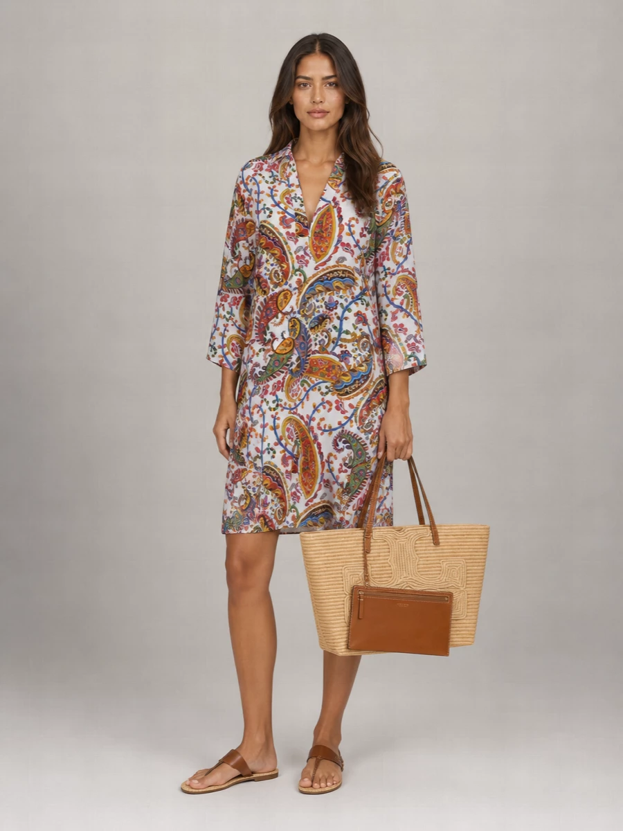 The Etro paisley shirt dress is the strongest anchor with the woven Tory Burch tote, echoing its warm neutrals while adding that softly bohemian print the bag invites. The easy, knee-grazing silhouette keeps the outfit light for warm days, and the Saint Laurent raffia-soled thong sandals pick up the straw and leather textures so everything feels intentionally sun-soaked and quietly polished.