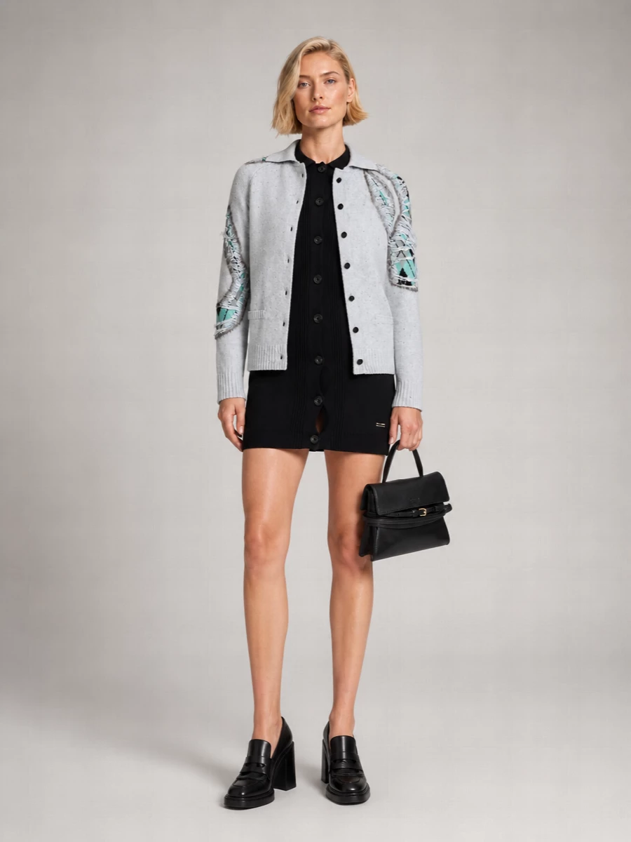 I’m styling the shredded Moschino cardigan as outerwear over the black slim knit shirt dress, so we skip extra separates and keep the line clean. The ribbed dress and block-heel loafers give a sharp, city-preppy base, while the mini black top-handle bag quietly picks up the cardigan’s black accents and gold hardware for a cohesive, slightly punk-ladylike finish. This combination lets the cardigan’s mint intarsia and deconstructed panels read as the statement without visual noise from competing colors or prints.