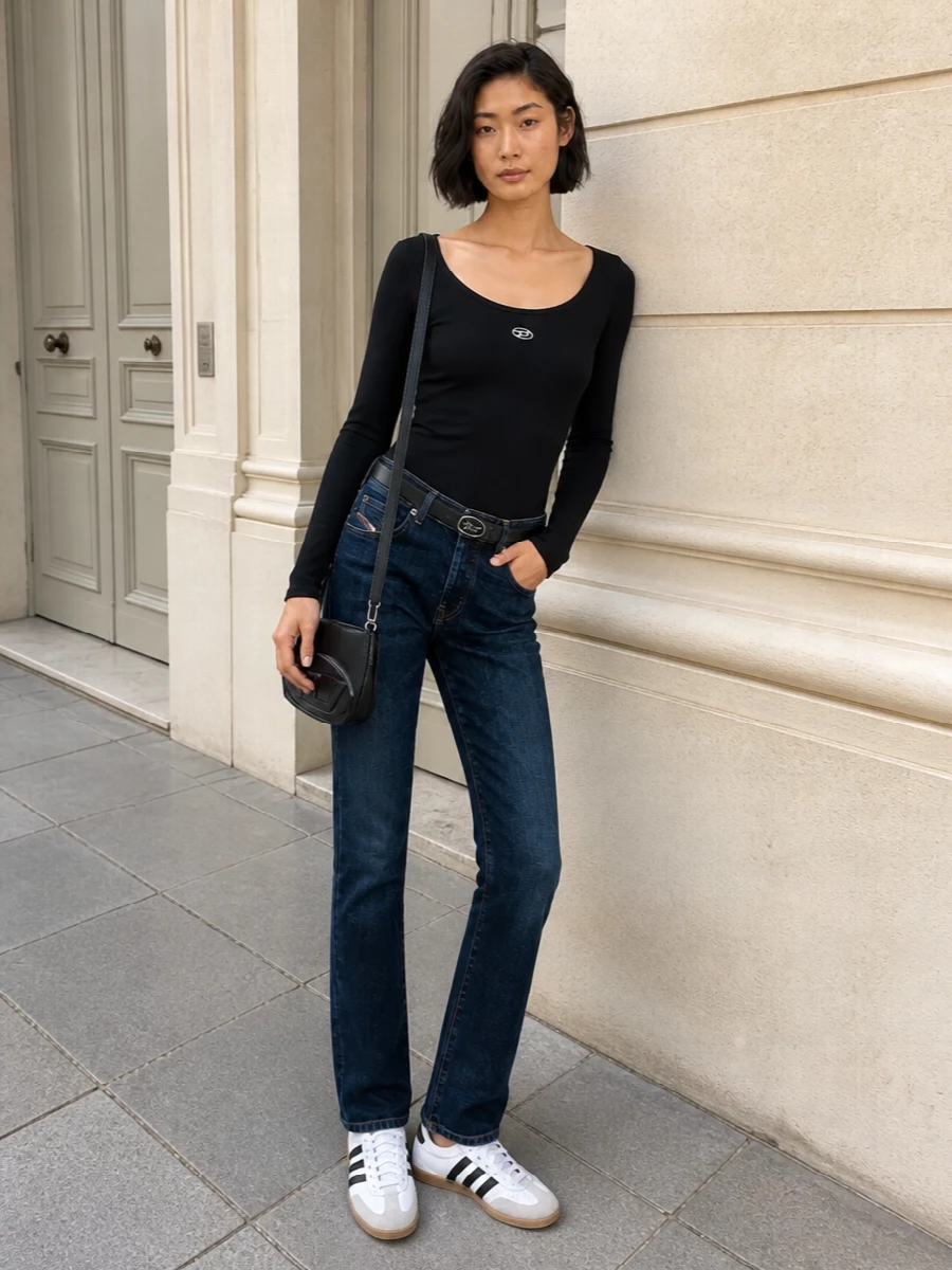 Dark straight Diesel denim with a slim black scoop-neck top keeps the line clean and unfussy, all in a tight indigo and black palette. Low-profile terrace sneakers and a small structured shoulder bag keep it practical for the city while the subtle belt detail quietly frames the waist.